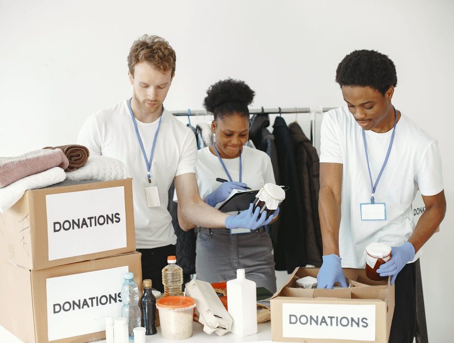 Volunteers sorting items into boxes marked donations