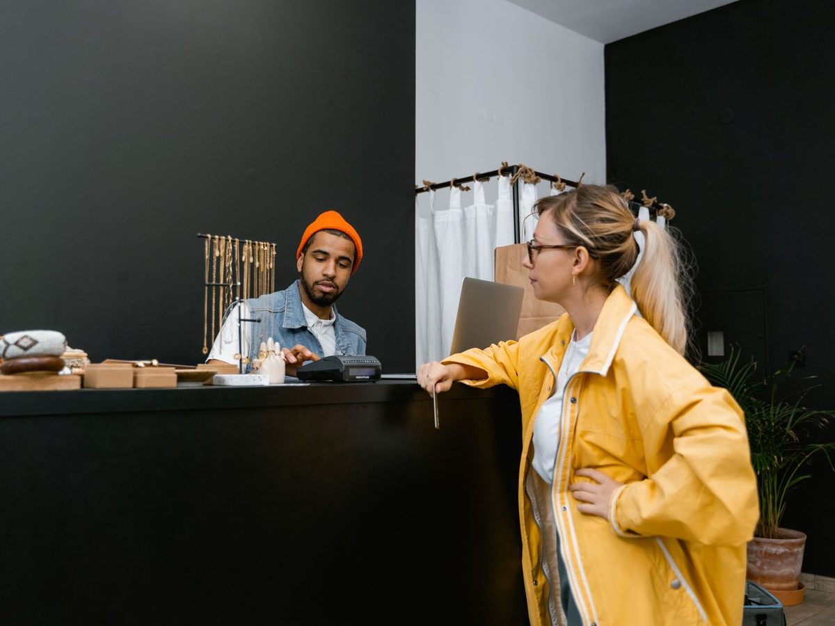 A customer paying by card at the counter of a small shop