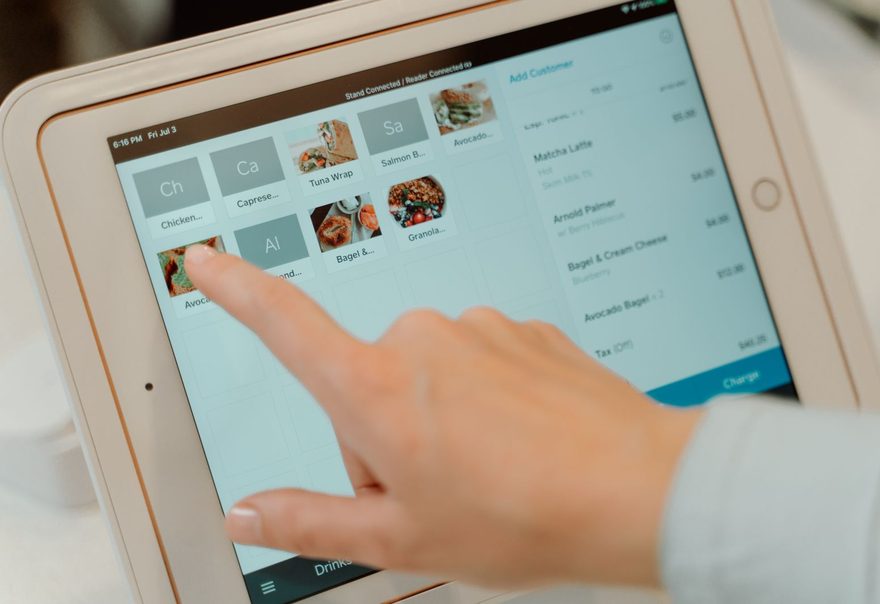 A tablet point-of-sale system on a stand showing an order screen