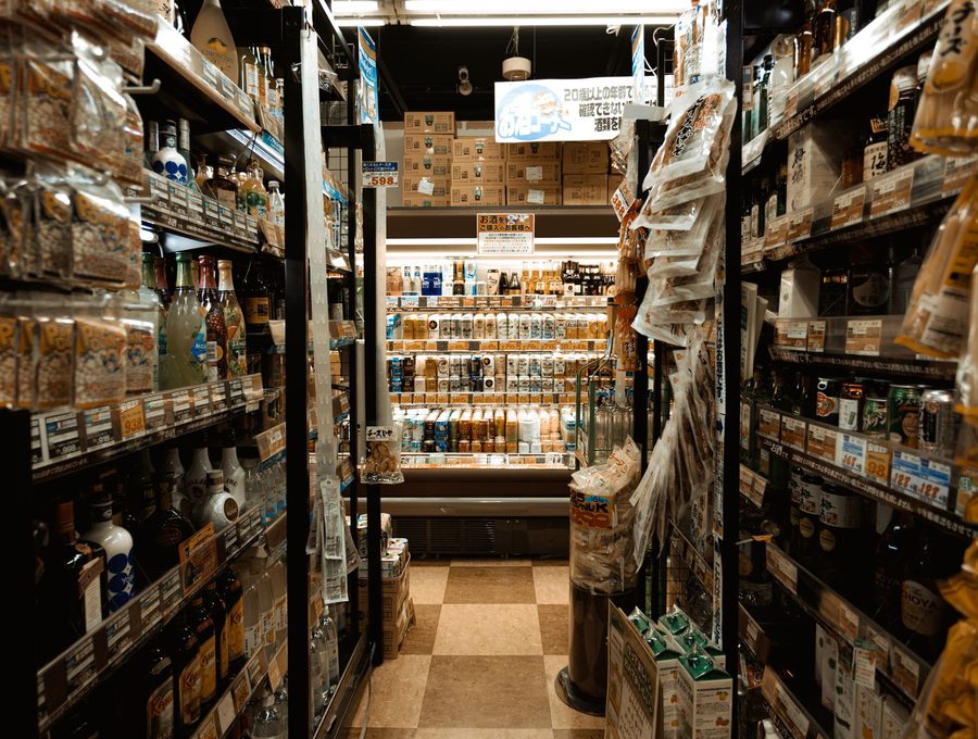 A narrow convenience store aisle stocked floor to ceiling