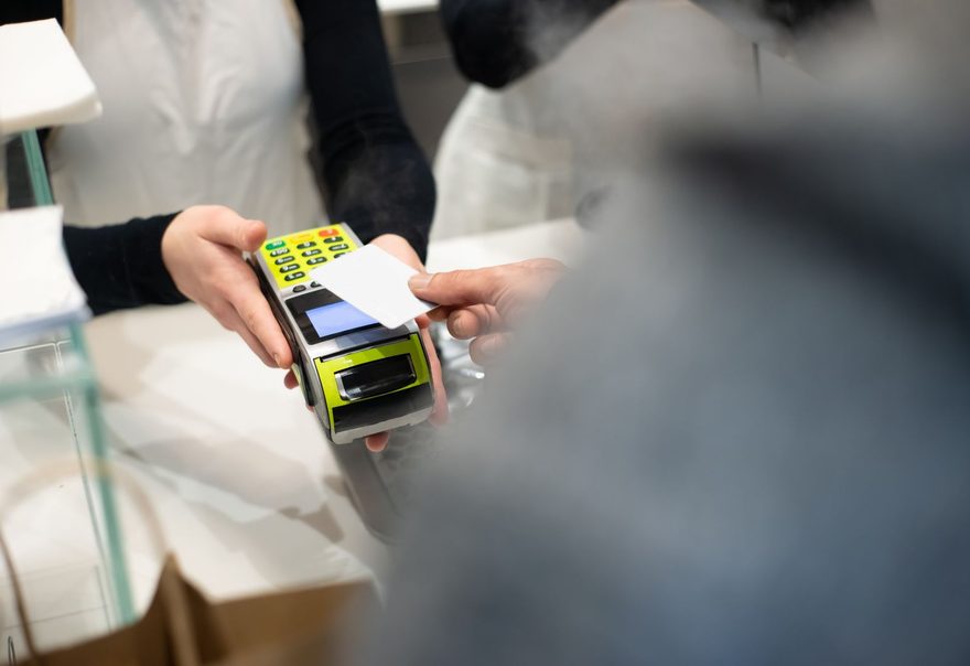 A customer paying at a handheld terminal in a store