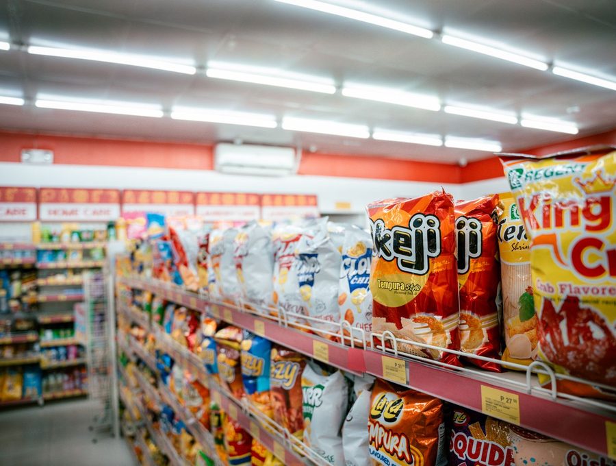A brightly lit snack aisle in a convenience store