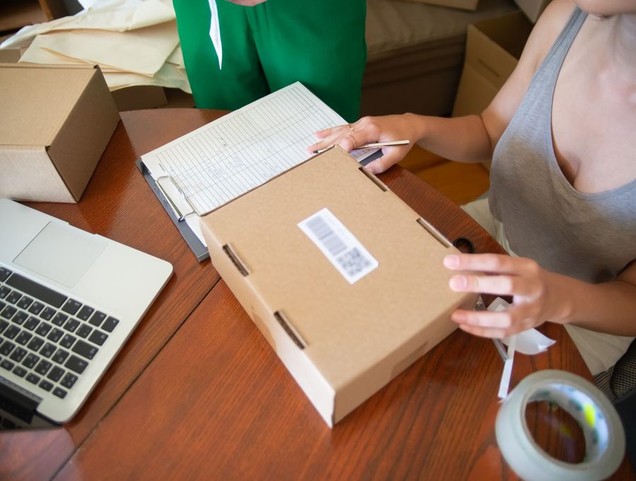 Someone packing and labelling an online order at a desk
