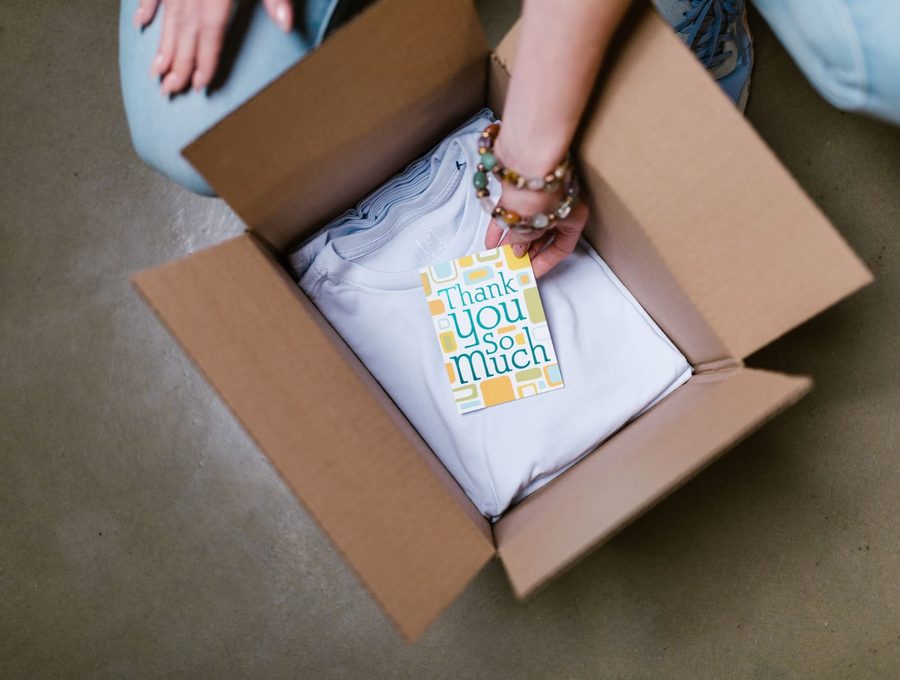Folded goods being packed into a subscription box