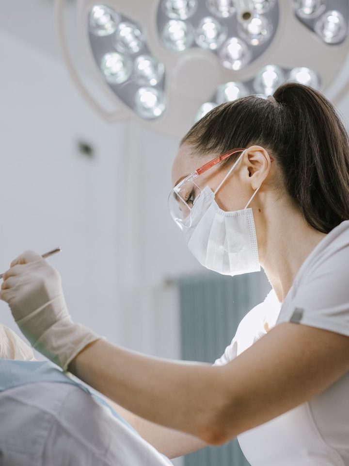 A dentist treating a patient under a surgical light
